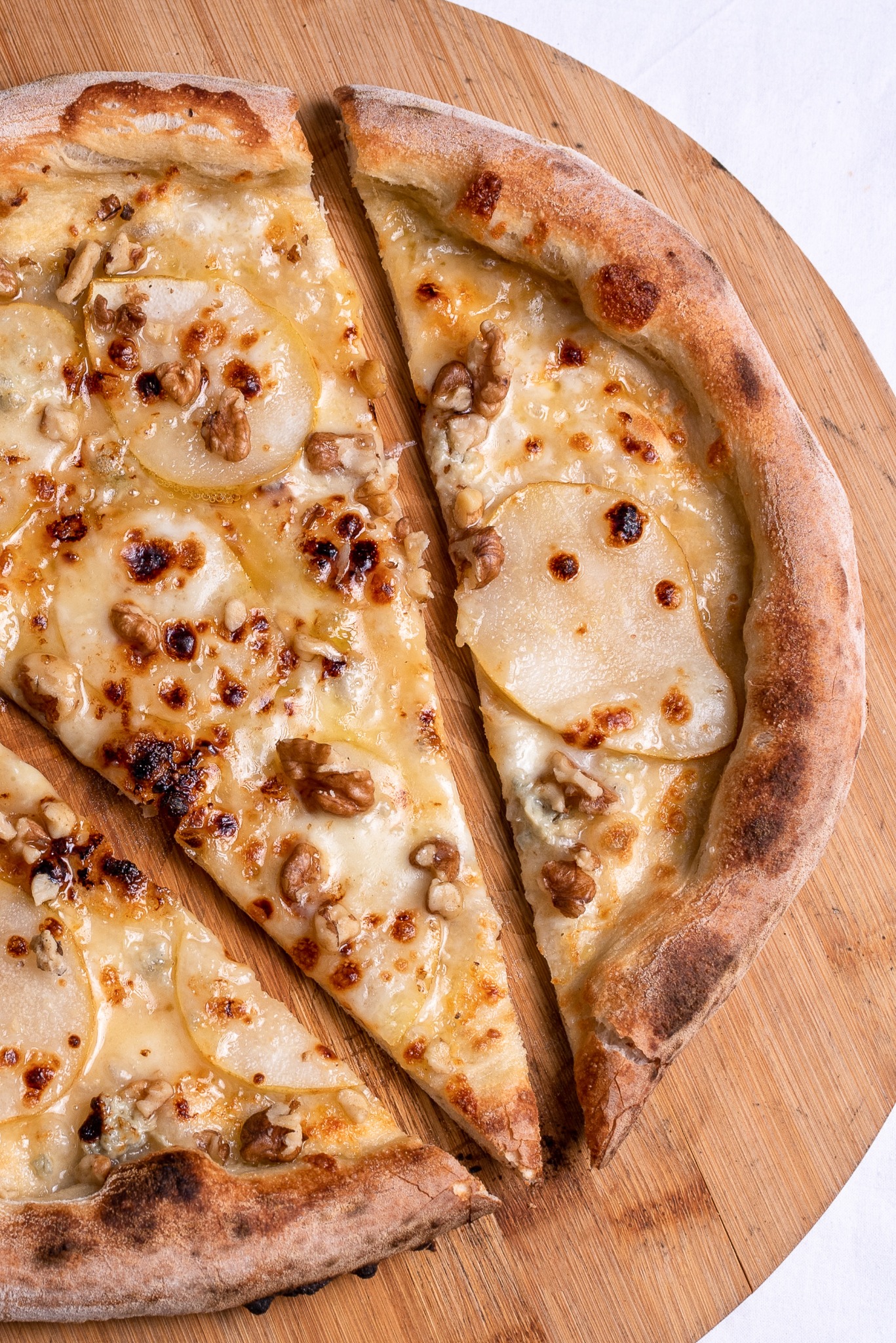 Pizza with pear slices on a wooden board